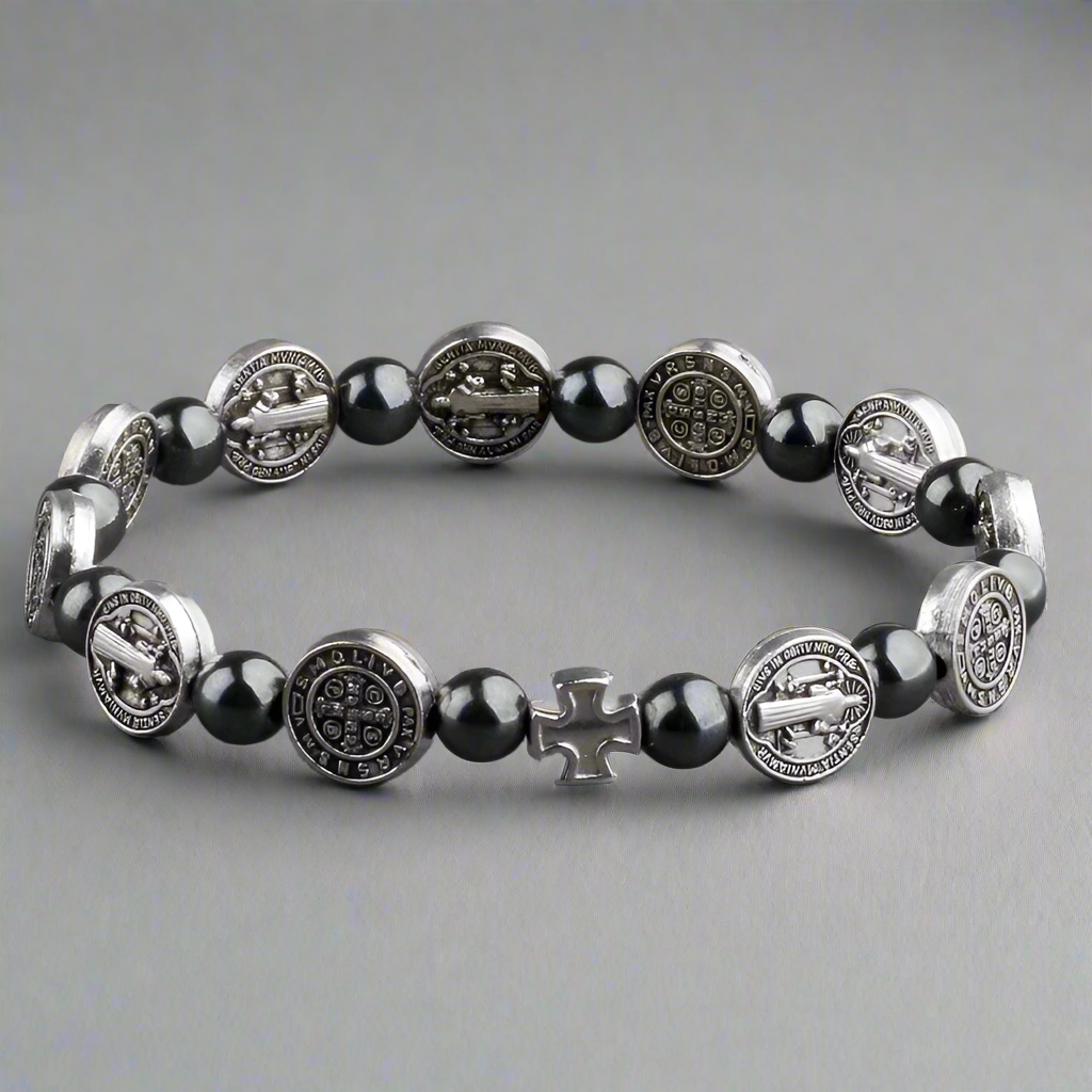 Bracelet with black beads and silver medallions on a gray background