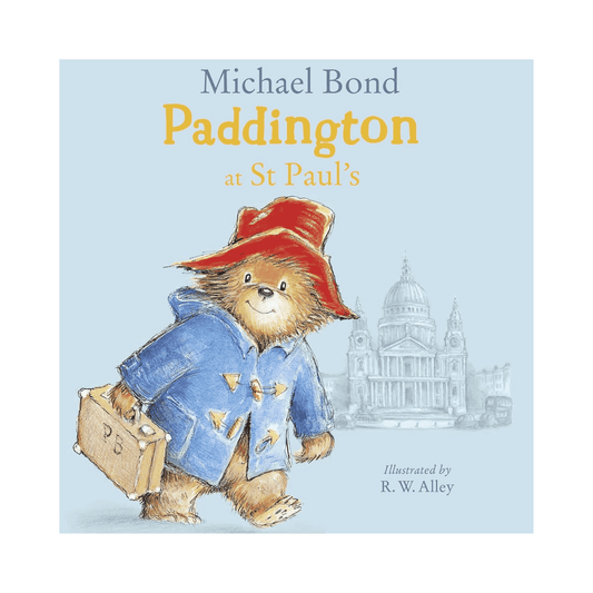 Book cover of 'Paddington at St Paul's' featuring Paddington Bear with a suitcase and red hat against a light blue background.
