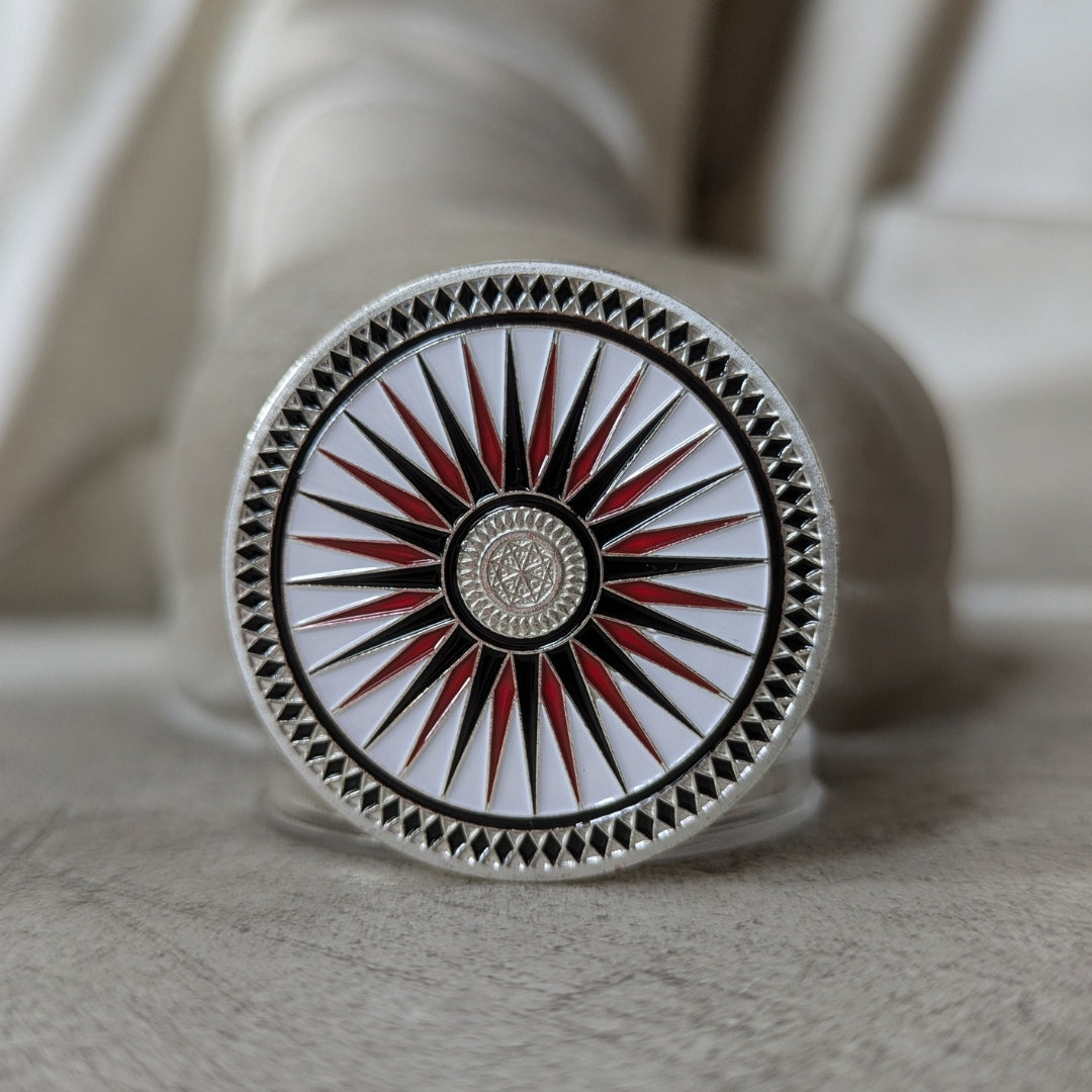 Decorative circular object with a starburst design on a textured surface