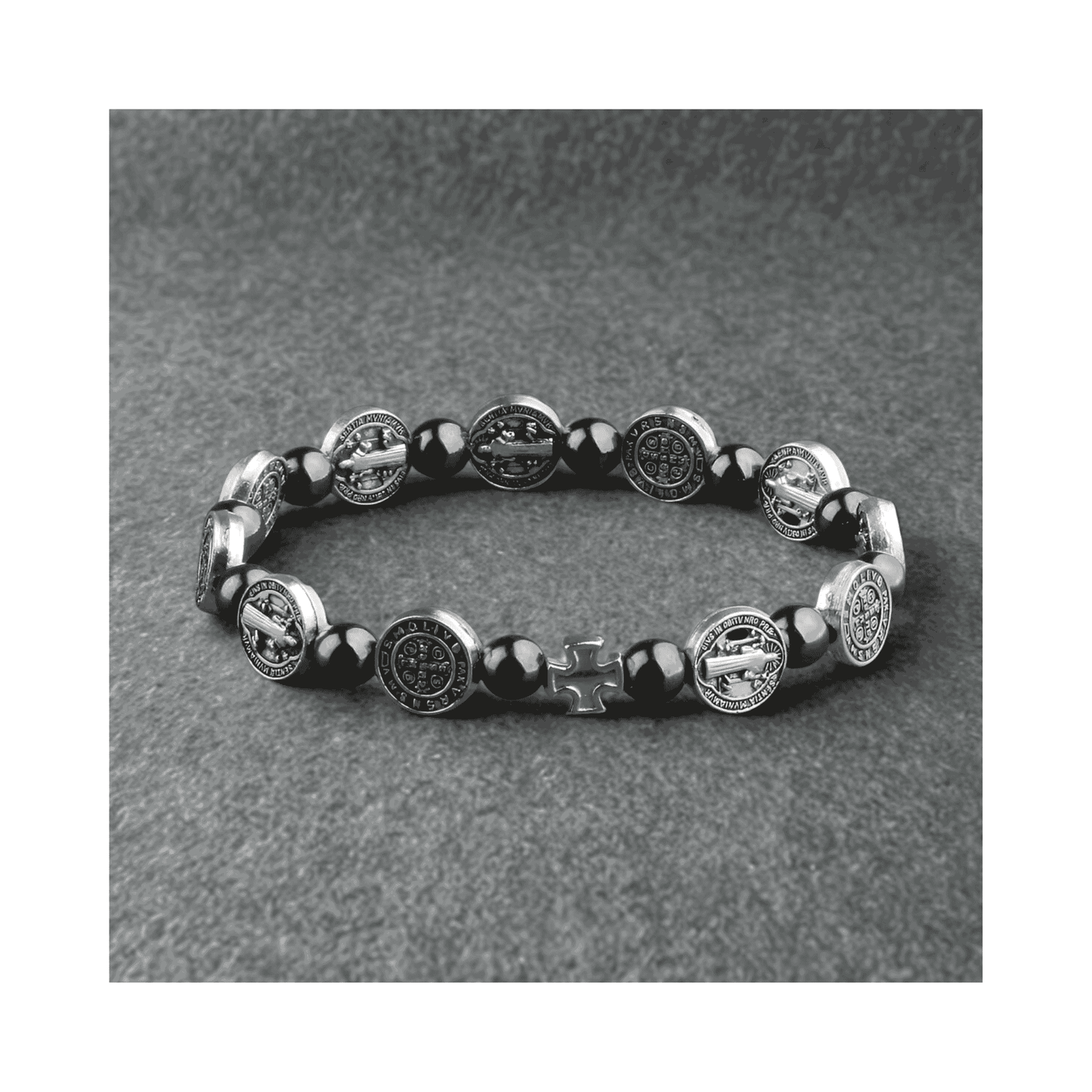 Bracelet with black beads and silver medallions on a gray background